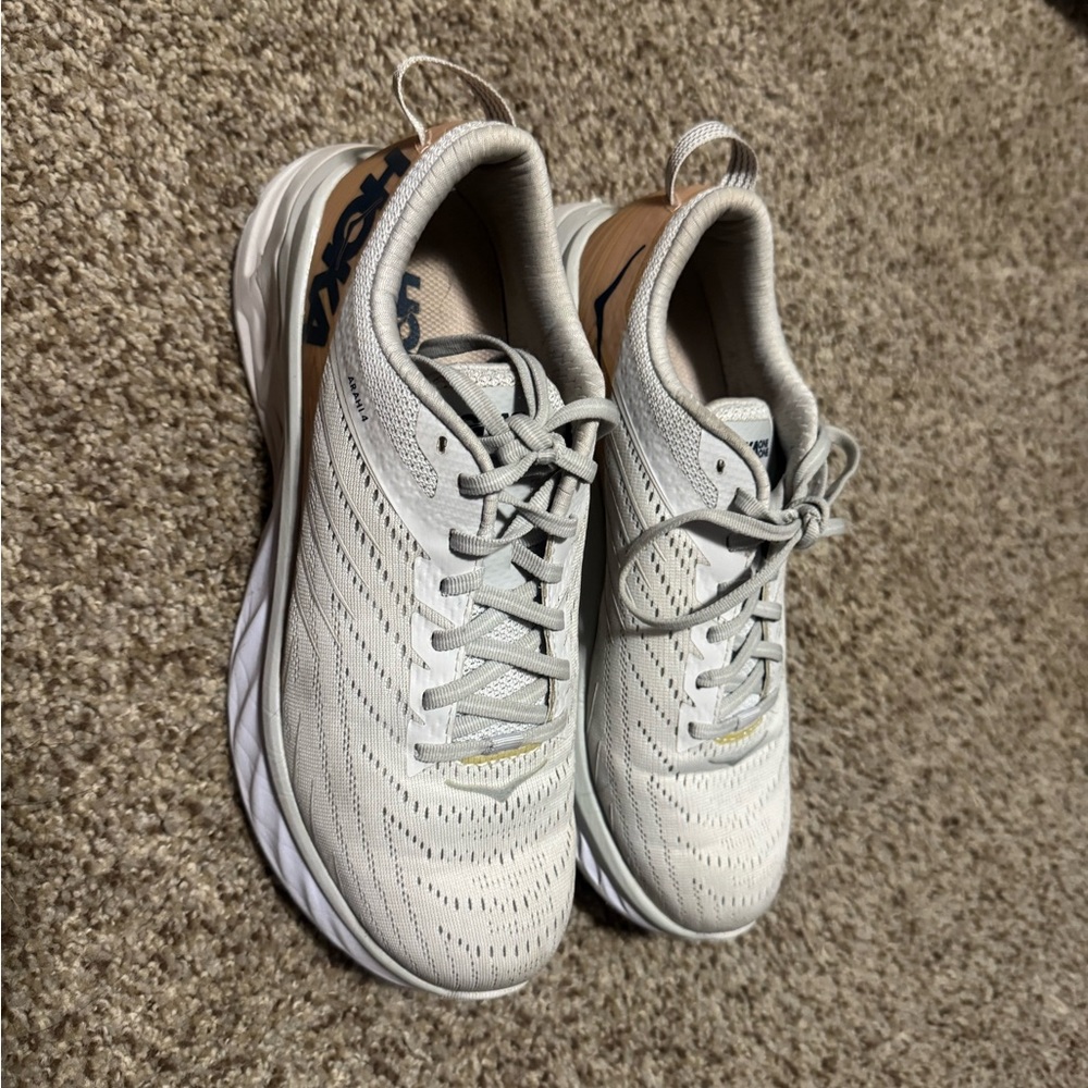 HOKA Women’s Arahi 4. Size 9. Cream color with some pink along the side.
